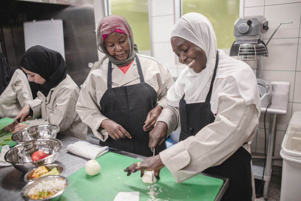 two women preparing food in a commercial kitchen