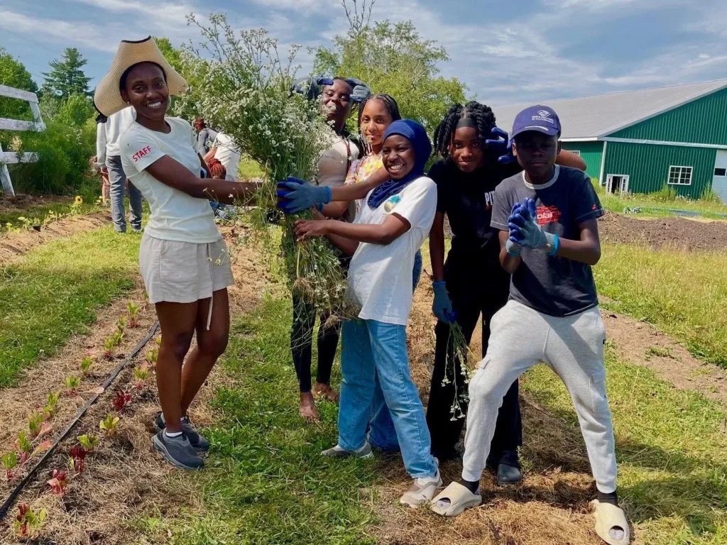 Six young people stop to pose for a phot at a garden planting